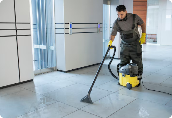 CT janitor cleaning floors in a commercial building to reduce dust and allergens in high-traffic areas.